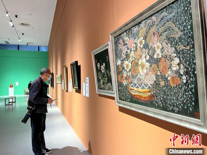 图为民众围观工艺美术大师及非遗代表性传承人作品。　钟旖摄